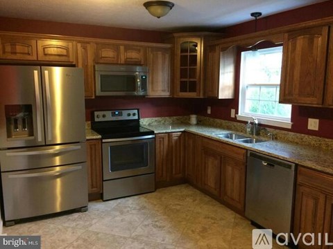 A kitchen with wooden cabinets and a stainless steel refrigerator.