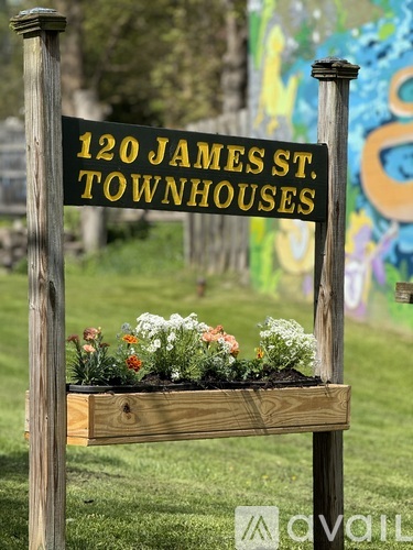 A wooden sign that says 120 James St. Townhouses.