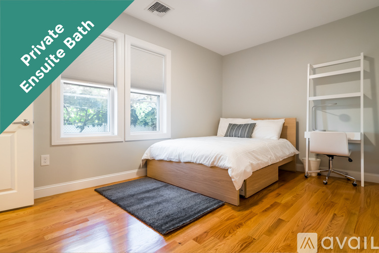 A bedroom with a bed, a chair, and a window.