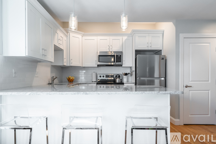 A kitchen with white cabinets and appliances.