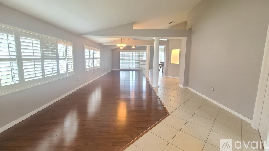 A spacious room with wooden floors and white walls.