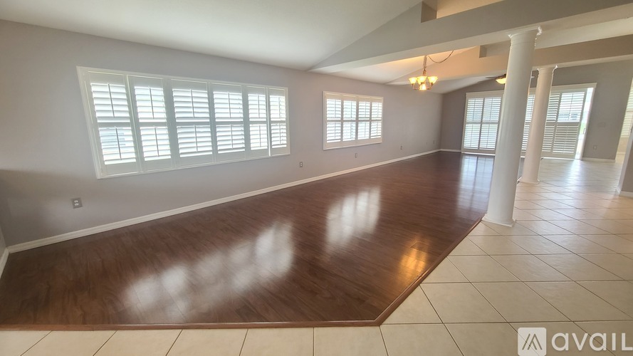 A spacious room with wooden floors and white walls.