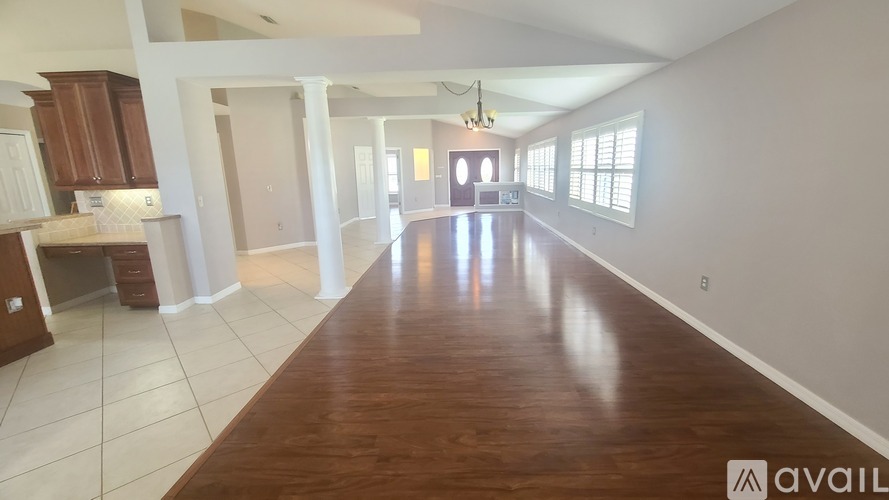 A spacious room with wooden floors and white walls.