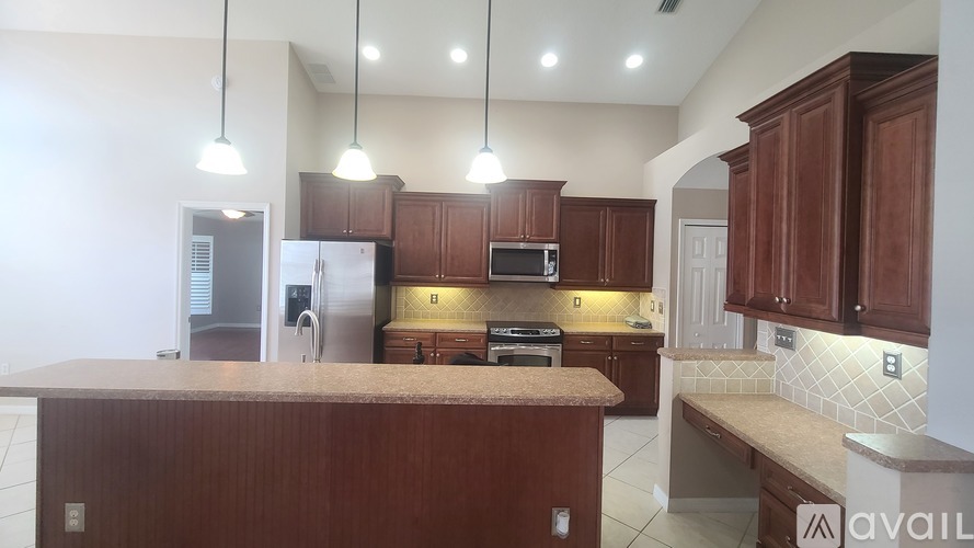 A kitchen with brown cabinets and a countertop is available for rent.