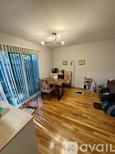 A living room with wooden floors and a white wall.