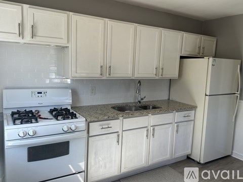 A kitchen with white cabinets and appliances.