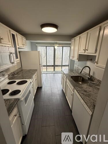 A kitchen with white cabinets and a granite countertop.