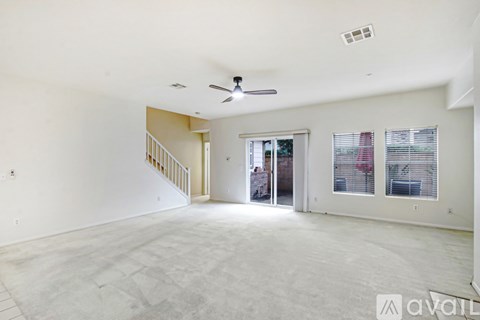 A spacious living room with a staircase leading to the upper floor.