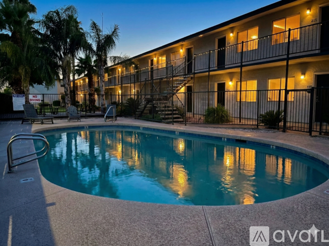 A pool in front of a building with Avail apartments written on the bottom right.
