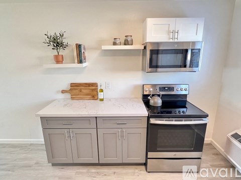 A kitchen with white cabinets and a white fridge.