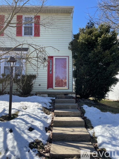A house with a red door and a snow-covered ground.