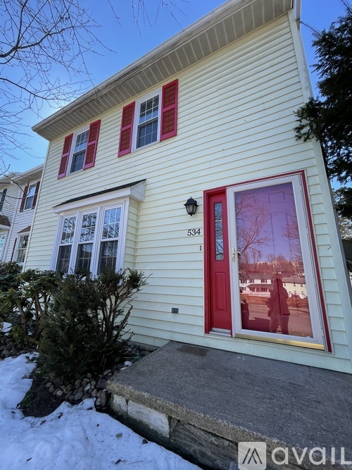 A house with a red door and windows is numbered 534.