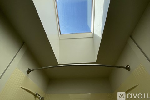 A bathroom with a skylight and a towel rack.
