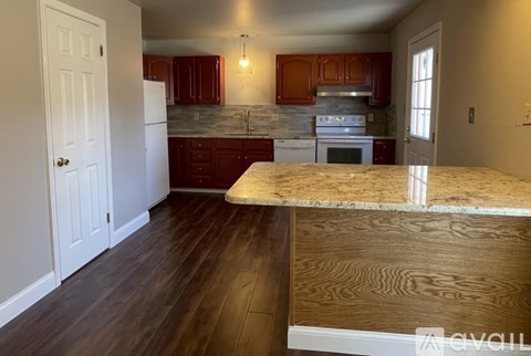 A kitchen with wooden cabinets and a marble countertop.