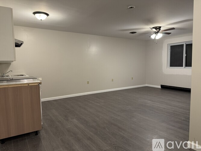 A room with a wooden cabinet and a ceiling fan.