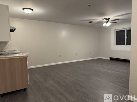 A room with a wooden cabinet and a ceiling fan.