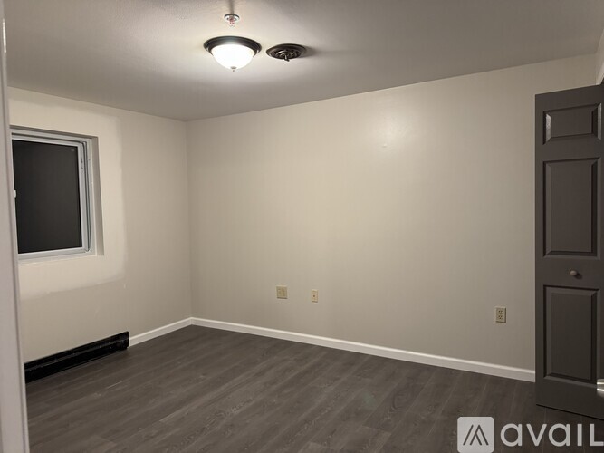 A room with a door, window, and a light fixture.