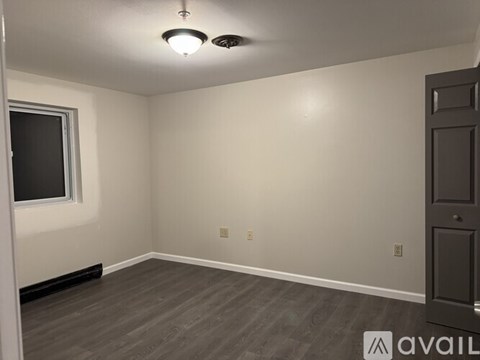 A room with a door, window, and a light fixture.