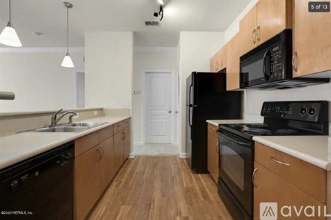 A kitchen with black appliances and wooden cabinets.