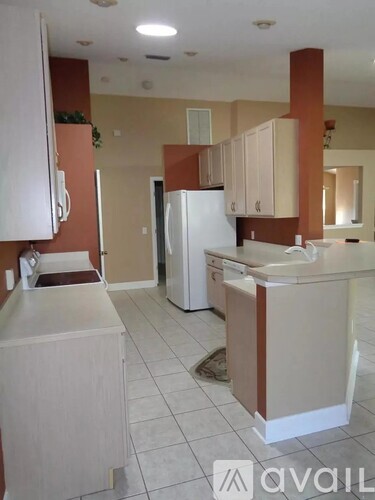 A kitchen with white appliances and cabinets.