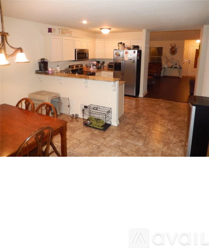 A kitchen with a refrigerator, microwave, and oven.
