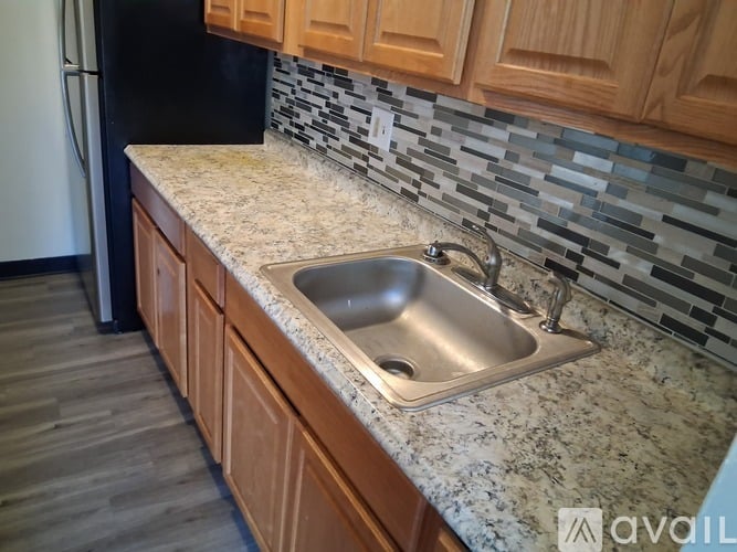 A kitchen with a sink and wooden cabinets.
