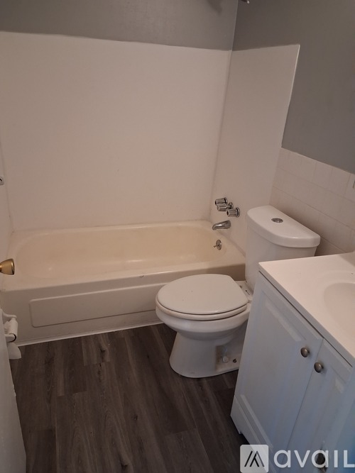 A white toilet sits next to a bathtub in a bathroom.