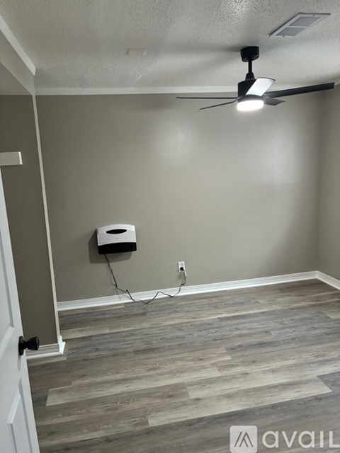 A room with a ceiling fan and a wall-mounted air conditioner unit.