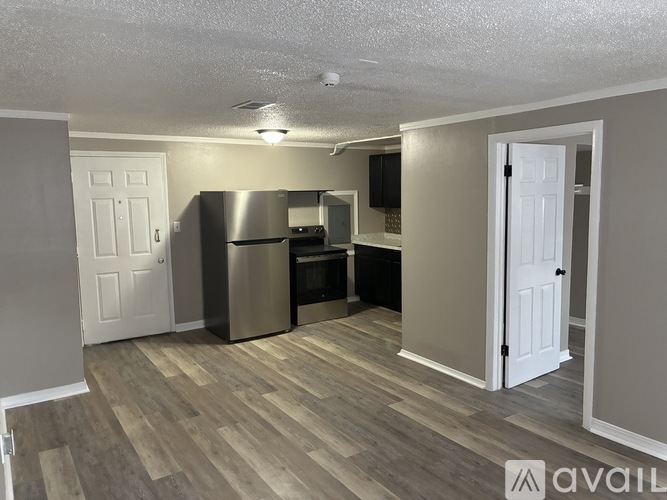A kitchen with a refrigerator, microwave, and oven.