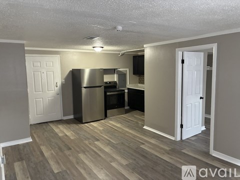 A kitchen with a refrigerator, microwave, and oven.