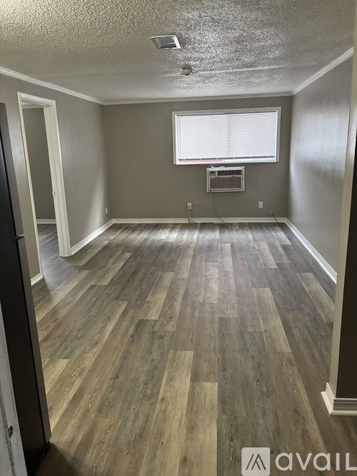 A room with wooden flooring and a window.