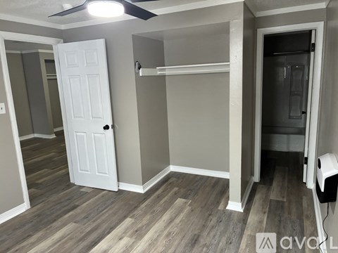 A room with a white door and a ceiling fan.