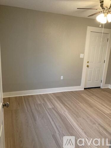 A room with a wooden floor and a white door.
