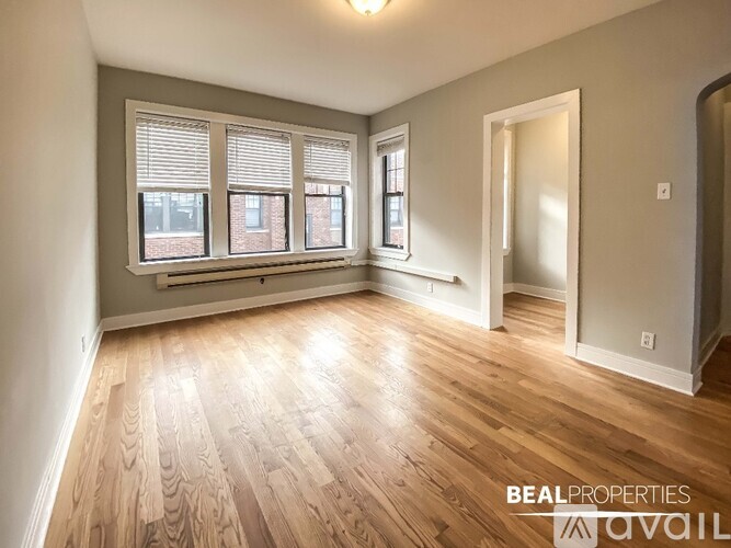 A room with wooden flooring and a window with blinds.