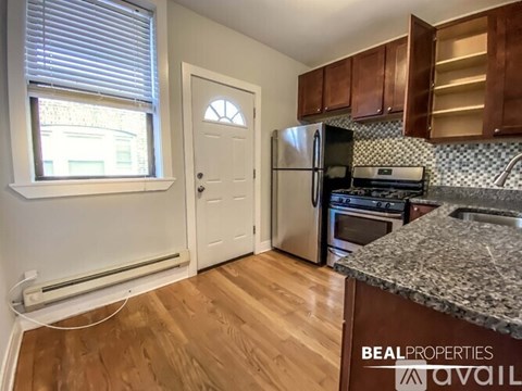 A kitchen with wooden floors and a granite counter top.