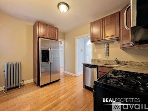 A kitchen with wooden cabinets and a black stove top oven.