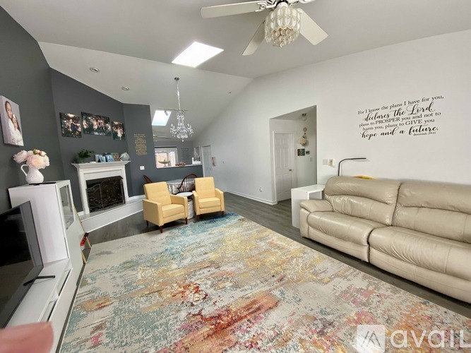 A living room with a rug, a couch, a television and a fireplace.