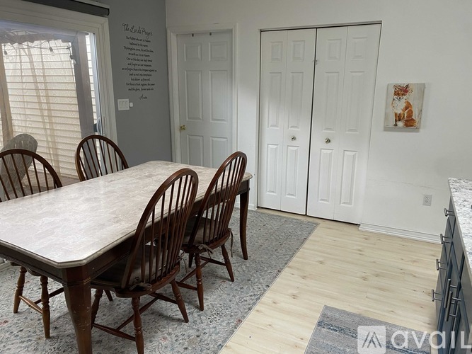 A dining room with a table and chairs.