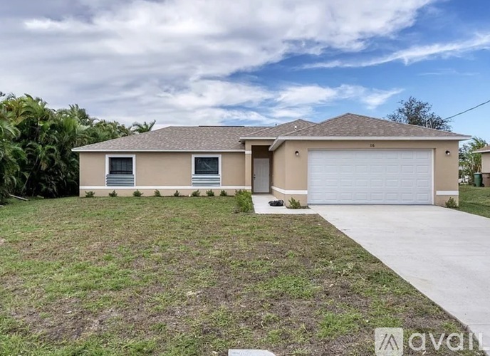 A beige house with a grey roof and a white garage door.