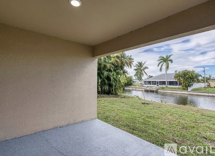 A balcony with a view of a river and palm trees.