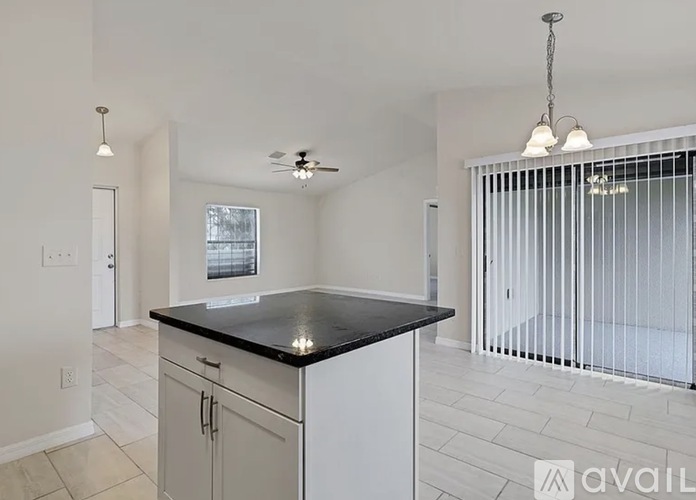 A kitchen with white cabinets and a black countertop.