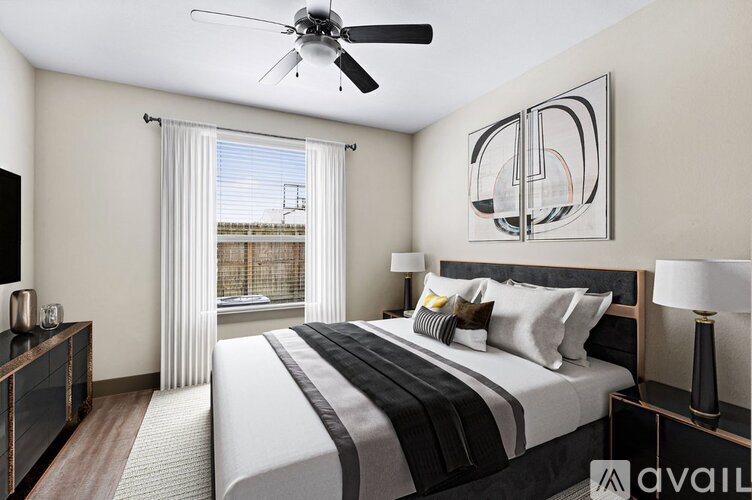 A bedroom with a large bed and a ceiling fan.