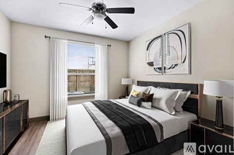 A bedroom with a large bed and a ceiling fan.