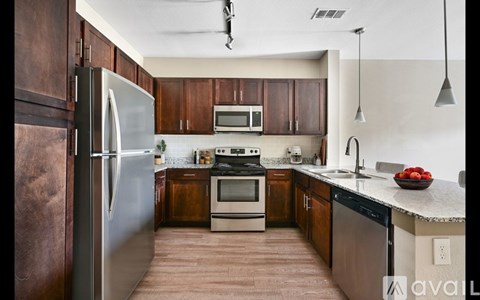 A kitchen with wooden cabinets and a stainless steel refrigerator.