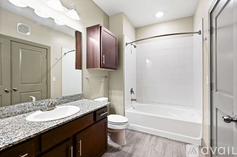 A bathroom with a white tub and a white sink.