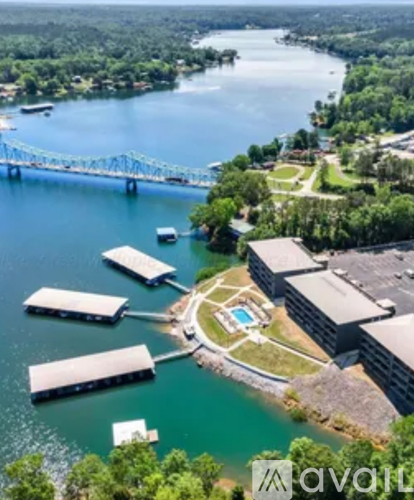 A bridge spans a river with a building and a pool in the foreground.