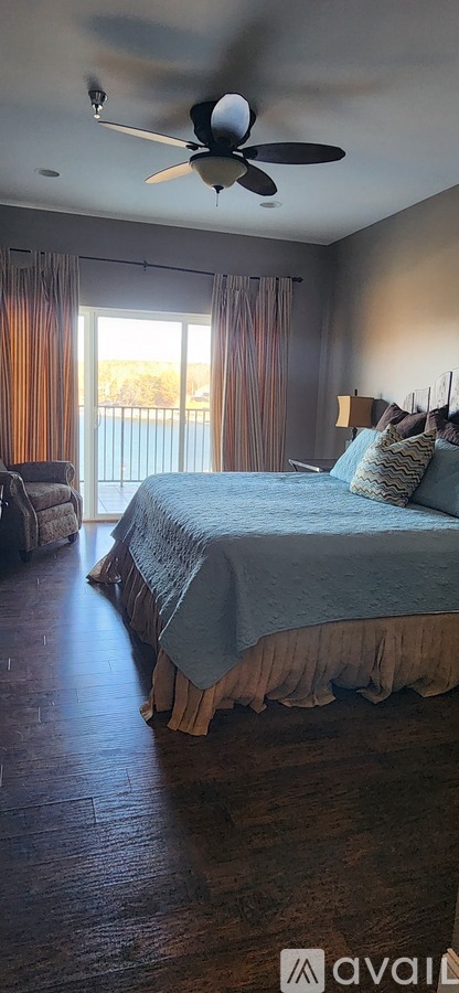 A bedroom with a bed and a ceiling fan.