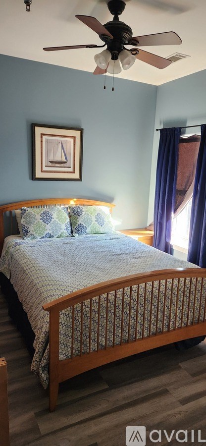 A bedroom with a bed and a ceiling fan.