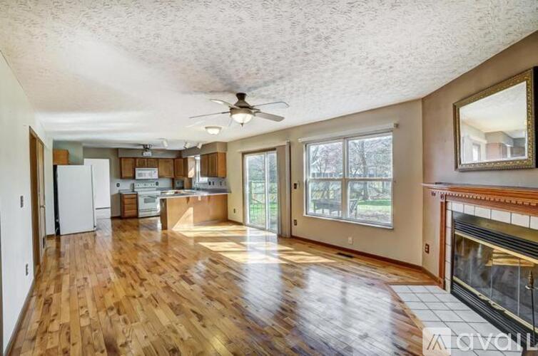 A spacious living room with wood flooring and a ceiling fan.