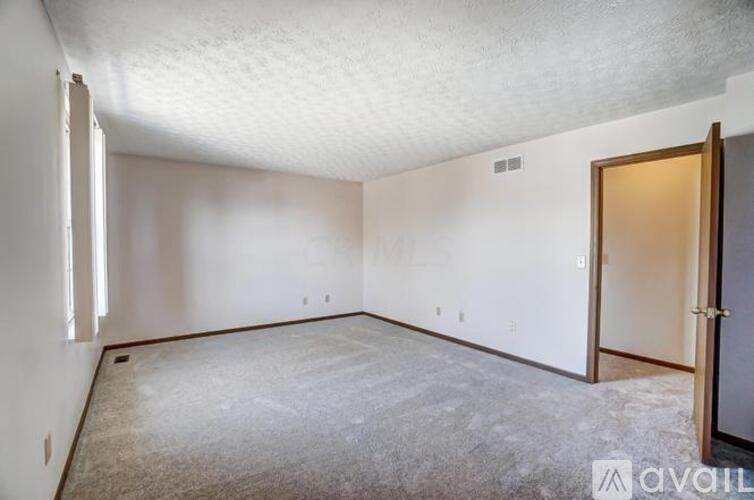 A spacious room with a door on the right side.